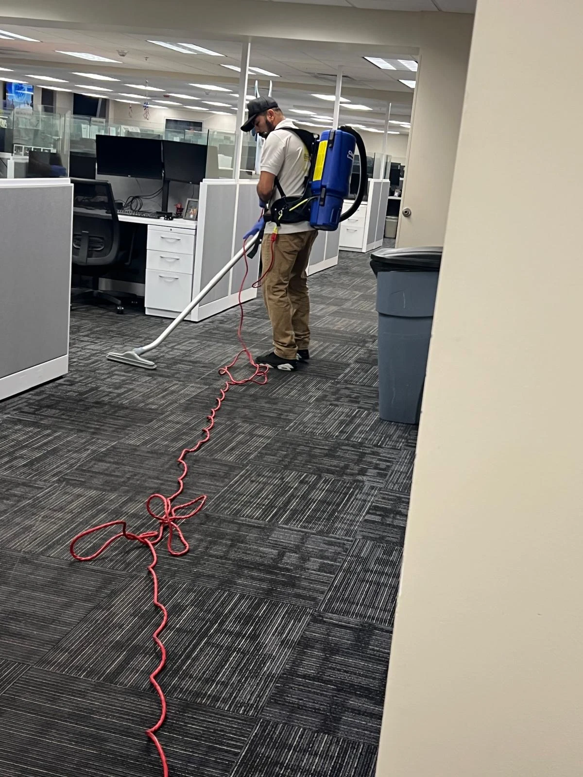 Rivera professional cleaning a carpeted office with a backpack vacuum